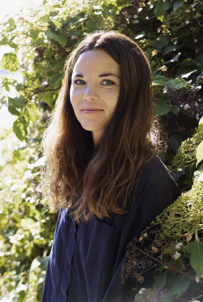 Portrettfoto av forfatter Julia Kahrs , utendørs med grønn bakgrunn