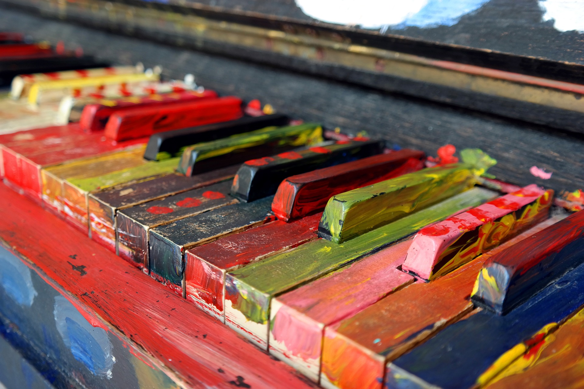Pianotangenter som er malt med røffe penselstrøk i alle regnbuens farger