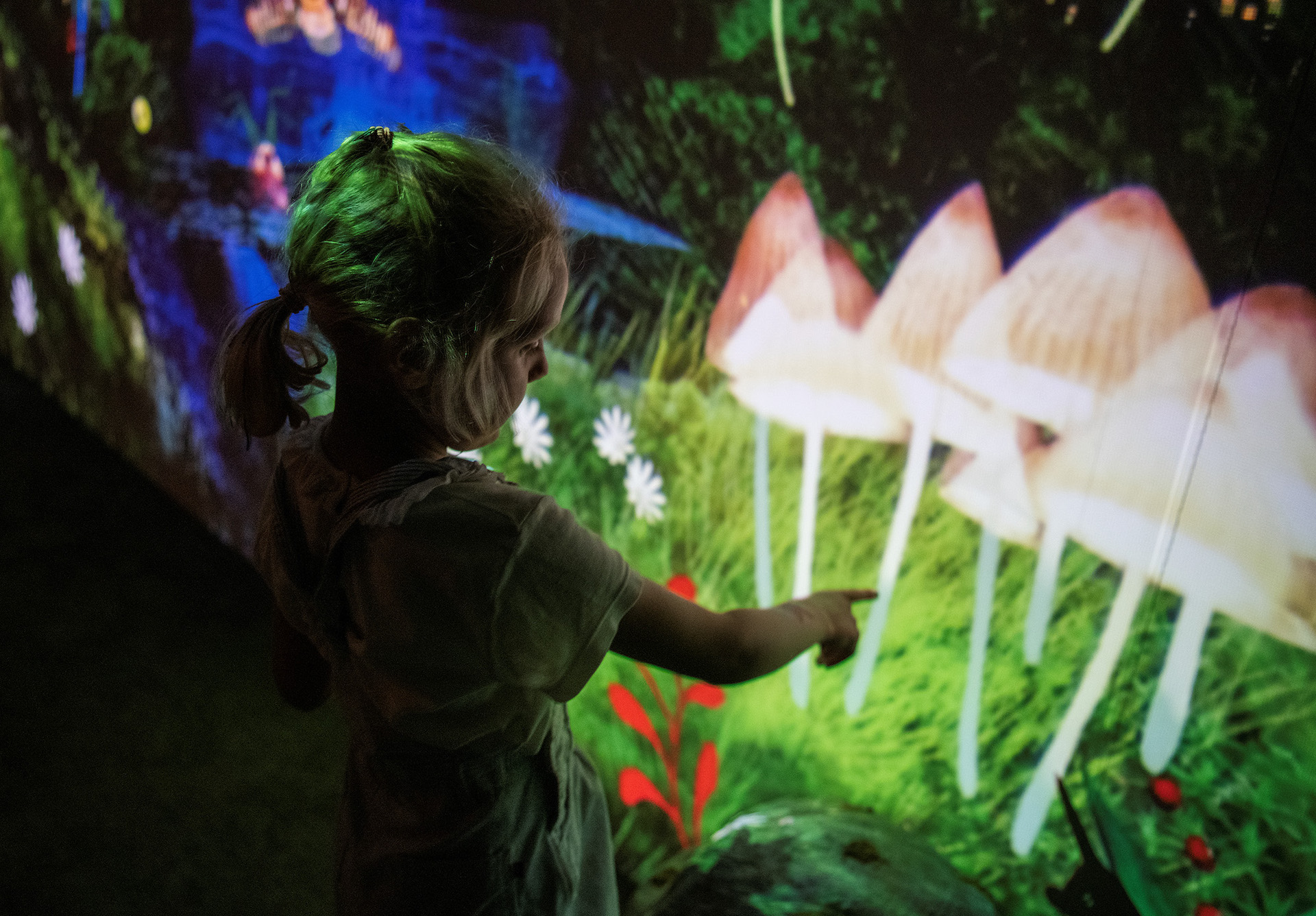 Barn peker på lysende sopp i en digital skog