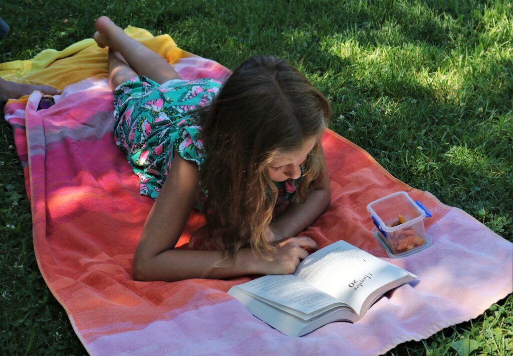 Barn som leser ute i parken